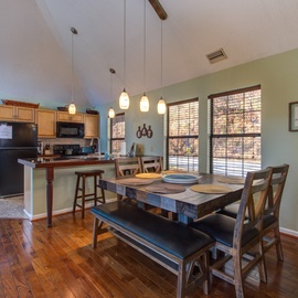Gather around your rustic dining table beneath warm pendant lights, with the full kitchen just steps away for easy meal prep.