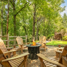 Gather around your private fire pit under the canopy of towering trees, perfect for evening conversations and toasting marshmallows in your peaceful backyard retreat.
