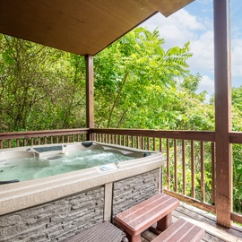 Soak in your private hot tub on the covered deck, surrounded by lush trees and fresh mountain air—perfect for unwinding after a day exploring nearby trails.