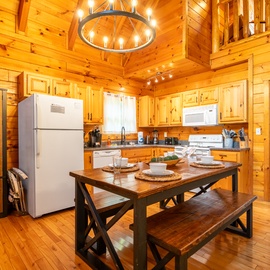 Step into your inviting mountain retreat with soaring vaulted ceilings and warm knotty pine throughout. The open kitchen and dining space features rustic wood furnishings where you can gather for home-cooked meals in cozy cabin comfort.