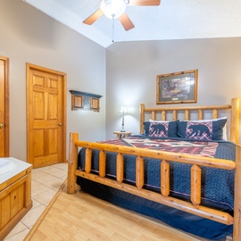 Relax in your rustic bedroom featuring log-style furnishings, cathedral ceilings, and cozy mountain-themed bedding.
