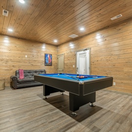 Challenge your group to friendly competition in this warm wood-lined game room, featuring a professional pool table and comfy seating for spectators.