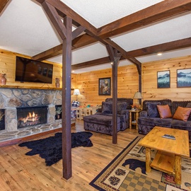 Unwind by the crackling fireplace in this cozy living area, where exposed beams and warm wood create your perfect mountain retreat. Sink into plush seating after a day of adventure.