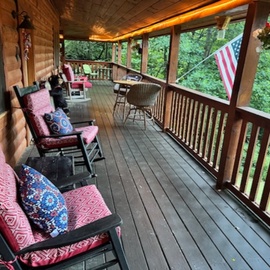 This charming covered porch is your peaceful retreat, with cozy rocking chairs overlooking lush greenery where you can relax and soak in the natural surroundings.
