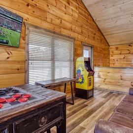 Your private game room features a vintage arcade, oversized checkers, and a cozy lounge area—perfect for unwinding after a day of adventure.