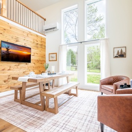 Relax in your bright living/dining space with warm wood accents, comfortable leather seating, and peaceful views.