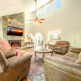 Sink into plush leather seating by your crackling stone fireplace, where soaring ceilings and natural light create the perfect retreat for cozy evenings.