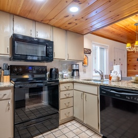 Your fully equipped kitchen awaits with modern appliances and granite counters, perfect for preparing meals in this cozy mountain retreat.
