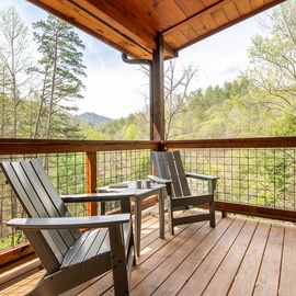 Unwind in your private mountain retreat, where comfortable Adirondack chairs await on this peaceful deck overlooking forest views.