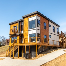 Modern hillside building featuring contemporary design with striking wood and exterior.