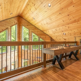 Step into your private game loft where soaring wood-paneled ceilings and forest views create the perfect setting for friendly competition and memorable evenings with loved ones.