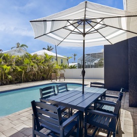 Pool area with seating with umbrella