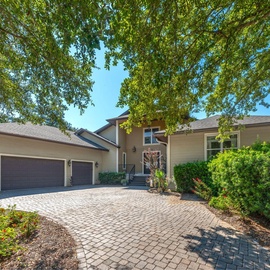 A graceful arrival beneath a canopy of trees, where the quiet setting welcomes you home.