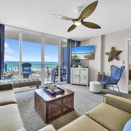 Sink into plush sofas while gentle ocean breezes flow through your beachfront living space, where tropical ceiling fans and stunning sea views create your perfect coastal retreat.