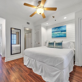 You'll drift off peacefully in this bright room with a king bed with ocean artwork and cozy linens, while the ceiling fan keeps you comfortable.