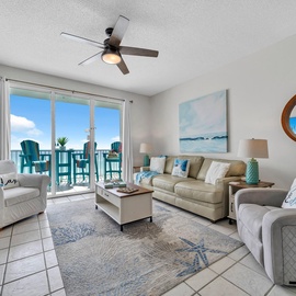 Relax in your coastal living room with ocean-themed decor and balcony views through floor-to-ceiling windows.