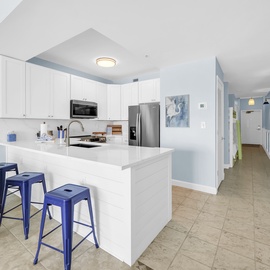 Your modern kitchen awaits with pristine white cabinets, stainless steel appliances, and a spacious island perfect for morning coffee or meal prep.