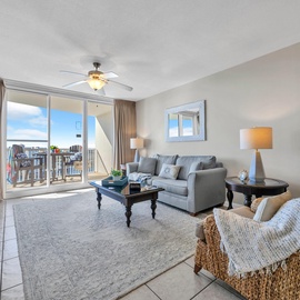 Relax in your bright living room with comfortable seating and expansive windows showcasing water views.