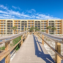 Azure is a beachfront property with convenient boardwalk access through pristine coastal dunes under brilliant blue skies.