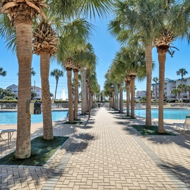A tropical resort-style pool area with swaying palm trees and beautiful landscaping awaits your perfect vacation retreat.