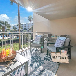 Your private balcony invites you to sip morning coffee while enjoying pool views and tropical palm scenery.