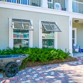 Charming coastal property with tropical landscaping and colorful brick pathways creating a welcoming beachside atmosphere for your getaway.