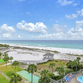 Stunning beachfront view showcasing pristine white sand, turquoise waters, and the property's pool below.