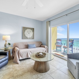 Sink into plush seating while gazing at stunning ocean views through floor-to-ceiling windows in your bright, coastal-themed living space.