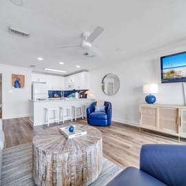 Unwind in your bright, coastal-inspired living space with comfortable seating and an open kitchen perfect for vacation gatherings.