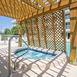 Unwind in your private hot tub oasis, where latticed shade and sparkling pool views create the perfect retreat.