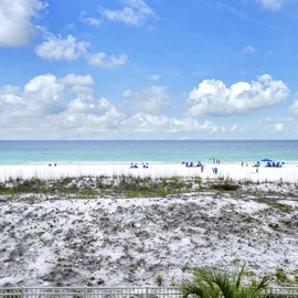 Pristine white sand beach with turquoise waters and fluffy clouds overhead. A peaceful coastal setting near the property, ideal for beach activities and seaside relaxation.