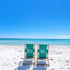 Pristine white sand beach with turquoise waters stretching endlessly under brilliant blue skies.