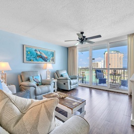 Relax in your coastal-themed living room with comfortable seating and stunning city views from your private balcony.