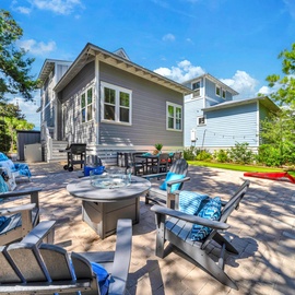 Spacious patio with comfortable seating and fire pit, surrounded by lush greenery for perfect outdoor relaxation.