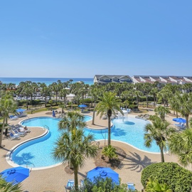 Stunning beachside resort with expansive pool complex and tropical landscaping near pristine coastline.