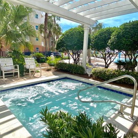 Slip into the hot tub oasis at Waterscape Resort, surrounded by lush tropical gardens and covered pergola for perfect relaxation.