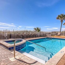 Dive into crystal-clear waters with a stunning beachfront pool deck featuring palm trees and ocean proximity.