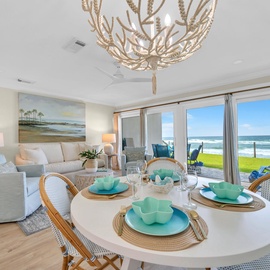 Your oceanfront retreat features an elegant dining space with stunning sea views through floor-to-ceiling windows.