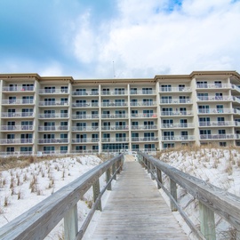 Beachfront property with direct access boardwalk leading through pristine white sand dunes to the shore.