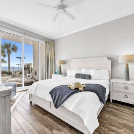 Wake to stunning beach views through floor-to-ceiling windows in your serene coastal primary bedroom retreat.