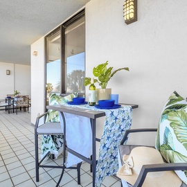 Enjoy your morning coffee on this spacious balcony with tropical-themed seating and refreshing blue accents that create the perfect coastal vibe.
