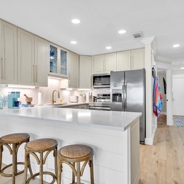 Your bright, modern kitchen awaits with gleaming counters, stainless appliances, and a breakfast bar perfect for morning coffee or evening chats.