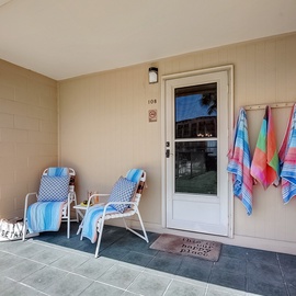 Your front patio at Venus 108 welcomes you with comfy lounge chairs and colorful beach towels ready for sunny days by the pool.
