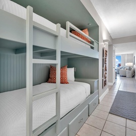 Rest easy in your cozy bunk beds with built-in storage, featuring soft linens and cheerful coastal colors for a perfect night's sleep.