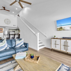 Relax in your bright, airy living space with soaring ceilings, coastal artwork, and stylish furnishings perfect for unwinding after beach adventures.