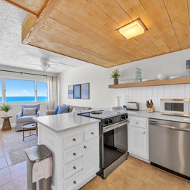 You'll love cooking with stunning ocean views in this bright kitchen featuring modern appliances and warm wood ceiling details.