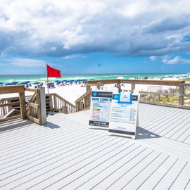 Beach access deck overlooking pristine white sand and emerald waters, with convenient boardwalk leading to coastal activities.