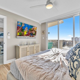 Wake up to stunning city views from your spacious bedroom with coastal-inspired decor and a ceiling fan for your comfort.