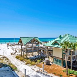 Pristine white sand beach with turquoise waters and convenient boardwalk access just steps from the property.