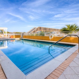 Sparkling rooftop pool with pristine blue waters and expansive terrace create your perfect escape under endless skies.